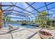 Screened outdoor pool area with lounge chairs, spa, outdoor kitchen, and views of the golf course at 7327 Greystone St, Lakewood Ranch, FL 34202