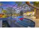 Illuminated pool with lush tropical landscaping, and a clear view of the tranquil waterfront at 7327 Greystone St, Lakewood Ranch, FL 34202