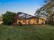 Beautiful backyard featuring a screened-in lanai, manicured lawn, and mature trees for added privacy at 7533 Trillium Blvd, Sarasota, FL 34241