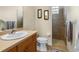 Bathroom featuring a sink and wooden vanity, toilet, and a shower with tile walls at 7533 Trillium Blvd, Sarasota, FL 34241