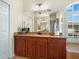 Bathroom with a wood vanity, granite countertops, large mirror, and door leading to the Primary bedroom at 7533 Trillium Blvd, Sarasota, FL 34241