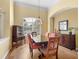 Formal dining room featuring wood floors, large window with shutters, elegant chandelier, and classic furnishings at 7533 Trillium Blvd, Sarasota, FL 34241