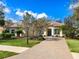 Charming front exterior of a home with lush landscaping, brick paved driveway, and a well-maintained lawn at 7533 Trillium Blvd, Sarasota, FL 34241