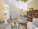 Open-concept living space with hardwood flooring, a bookshelf, and a clear view to the front entrance and dining area at 7533 Trillium Blvd, Sarasota, FL 34241