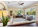 Bright and airy living room with hardwood floors, comfortable seating, and a view of the backyard and pool at 7533 Trillium Blvd, Sarasota, FL 34241