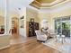 Elegant living room with hardwood floors, coffered ceilings, a bookshelf and refined furnishings at 7533 Trillium Blvd, Sarasota, FL 34241