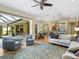 Bright living room with hardwood floors, stylish rug, modern furnishings, and seamless indoor-outdoor flow to screened patio at 7533 Trillium Blvd, Sarasota, FL 34241