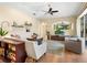 Inviting living room with a ceiling fan, hardwood floors, modern decor, and a view of the backyard pool at 7533 Trillium Blvd, Sarasota, FL 34241