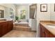Luxurious main bathroom featuring a soaking tub, walk-in shower, and ample vanity space with wood cabinetry at 7533 Trillium Blvd, Sarasota, FL 34241