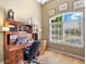 Office space with built-in wooden desk, chair, decorations and a large window with shutters at 7533 Trillium Blvd, Sarasota, FL 34241