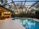 Inviting screened-in pool area featuring a uniquely shaped pool, covered patio, and serene backyard views at 7533 Trillium Blvd, Sarasota, FL 34241