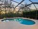 Screened pool with outdoor lighting and blue trim, offering a refreshing backyard oasis at 7533 Trillium Blvd, Sarasota, FL 34241