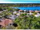 An aerial view showcasing a neighborhood's tiled-roof homes, lush greenery, and serene lake views on a clear day at 8224 Waterview Blvd, Lakewood Ranch, FL 34202
