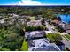 Wide aerial shot featuring the home nestled in a lush, green neighborhood near a lake at 8224 Waterview Blvd, Lakewood Ranch, FL 34202