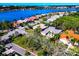 Aerial view of a community's tiled-roof houses, scenic lakefront, and lush trees on a bright sunny day at 8224 Waterview Blvd, Lakewood Ranch, FL 34202