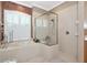 Bright bathroom featuring tiled tub with window and separate glass enclosed shower at 8224 Waterview Blvd, Lakewood Ranch, FL 34202