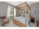 Spacious bedroom featuring a four poster bed, rocking chair and large window at 8224 Waterview Blvd, Lakewood Ranch, FL 34202