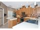 Kitchen with wood cabinets, stainless appliances, mosaic backsplash, and a double basin sink at 8224 Waterview Blvd, Lakewood Ranch, FL 34202