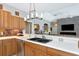Bright kitchen featuring wooden cabinets, mosaic backsplash, stainless steel appliances, and stylish lighting fixture at 8224 Waterview Blvd, Lakewood Ranch, FL 34202