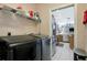 Spacious laundry room with washer and dryer, storage shelves, and stainless-steel appliances nearby at 8224 Waterview Blvd, Lakewood Ranch, FL 34202