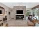Open living room features a stone accent wall, fireplace, and sliding glass doors with views of the screened lanai at 8224 Waterview Blvd, Lakewood Ranch, FL 34202