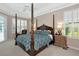Spacious main bedroom featuring a four-poster bed, tray ceilings, and plantation shutters at 8224 Waterview Blvd, Lakewood Ranch, FL 34202