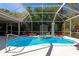 Beautiful pool with a spa, surrounded by a screened enclosure and lush green trees at 8224 Waterview Blvd, Lakewood Ranch, FL 34202