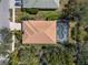 Aerial view of the home showcasing the screened-in pool, roof, and the surrounding lush landscaping at 866 Placid Lake Dr, Osprey, FL 34229