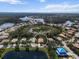 Wide aerial view of property in a community surrounded by ponds, lakes, trees, and other neighborhood homes at 866 Placid Lake Dr, Osprey, FL 34229