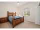 Comfortable bedroom featuring a wood bed frame, bedside table, arched window, and plush carpet at 866 Placid Lake Dr, Osprey, FL 34229