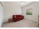 Cozy bedroom featuring a comfortable red sofa, neutral carpet, and a bright window offering natural light at 866 Placid Lake Dr, Osprey, FL 34229