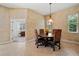 Dining room with a wooden table, four cushioned chairs, and a hanging light fixture at 866 Placid Lake Dr, Osprey, FL 34229