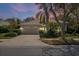 Lovely home at twilight features a paved driveway, tile roof, lush landscaping, and an attached two-car garage at 866 Placid Lake Dr, Osprey, FL 34229