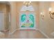 Spacious foyer with decorative glass doors, neutral paint, tile flooring, and decorative wall mounted lights at 866 Placid Lake Dr, Osprey, FL 34229