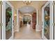 Elegant foyer with decorative glass doors, neutral tile flooring, columns, archways, and a view into the living room at 866 Placid Lake Dr, Osprey, FL 34229