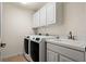 Functional laundry room equipped with a washer, dryer, sink, and white cabinetry for storage and organization at 866 Placid Lake Dr, Osprey, FL 34229