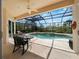 Screened-in lanai with a pool, fountain, and greenery beyond the screened enclosure at 866 Placid Lake Dr, Osprey, FL 34229