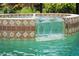 Close-up shot of a fountain cascading into a beautifully tiled spa in the swimming pool at 866 Placid Lake Dr, Osprey, FL 34229