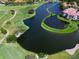 This is an aerial view of the golf course showcasing a lake and surrounding homes and golf greens at 8681 Daydream St, Sarasota, FL 34238