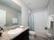 Well-lit bathroom featuring a tub, shower with a curtain, and granite vanity top, with modern fixtures at 8681 Daydream St, Sarasota, FL 34238