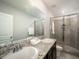 Bright bathroom with granite countertops, double sinks, and a glass-enclosed shower, offering a luxurious feel at 8681 Daydream St, Sarasota, FL 34238