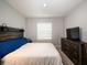 Comfortable bedroom featuring a wooden bed frame, dresser, and a large window, creating a cozy and relaxing atmosphere at 8681 Daydream St, Sarasota, FL 34238