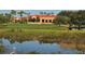 Beautiful clubhouse nestled amidst lush landscaping and a tranquil pond reflecting the building's elegant architecture at 8681 Daydream St, Sarasota, FL 34238