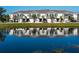 Beautiful townhome exterior featuring a tranquil pond view and lush landscaping at 8681 Daydream St, Sarasota, FL 34238