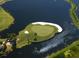 Aerial view of the golf course featuring a unique island green surrounded by water at 8681 Daydream St, Sarasota, FL 34238