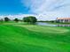 Picturesque golf course with manicured greens and scenic water features under a clear blue sky, perfect for a relaxing day at 8681 Daydream St, Sarasota, FL 34238
