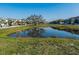 Scenic view of a pond reflecting the surrounding community and trees, offering a tranquil and picturesque setting at 8681 Daydream St, Sarasota, FL 34238