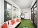 Relaxing sunroom featuring artificial turf, a sofa with accent pillows, and a hanging chair, a great living space at 8681 Daydream St, Sarasota, FL 34238