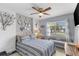 Cozy bedroom features a stylish accent wall, a ceiling fan, and a window seat at 8719 Gaillard Ave, North Port, FL 34287