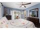 Bedroom showcasing a bed with a floral quilt, dressers, and a sliding glass door to the patio at 8719 Gaillard Ave, North Port, FL 34287